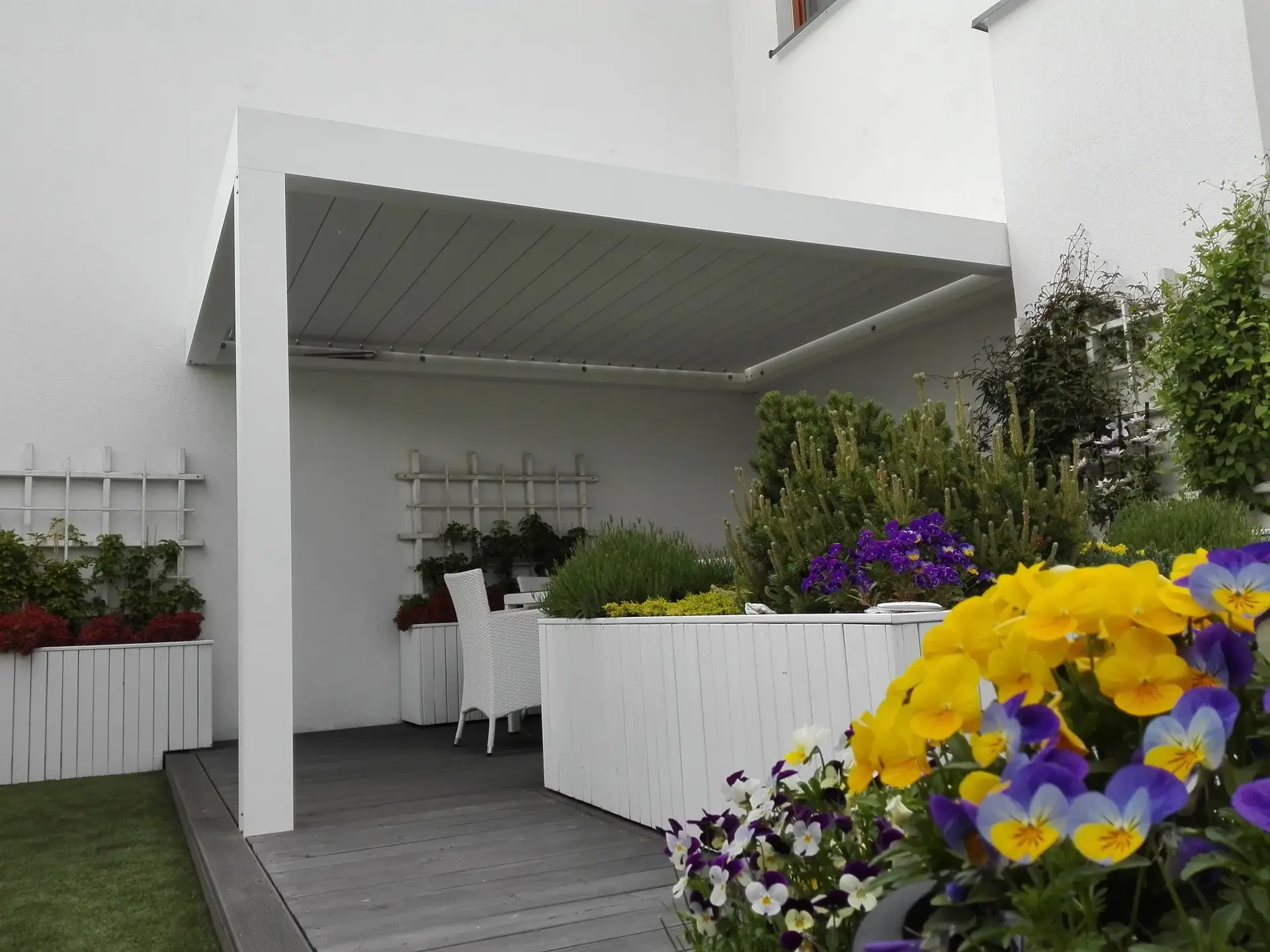 Biela bioklimatická pergola s kvetmi na terase