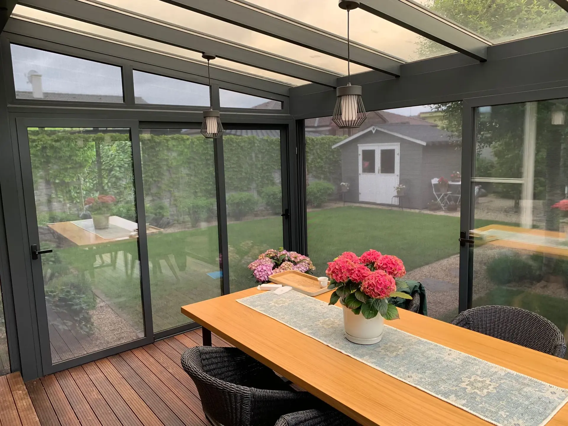 Zasklená pergola, pohľad zvnútra na stôl s kvetmi