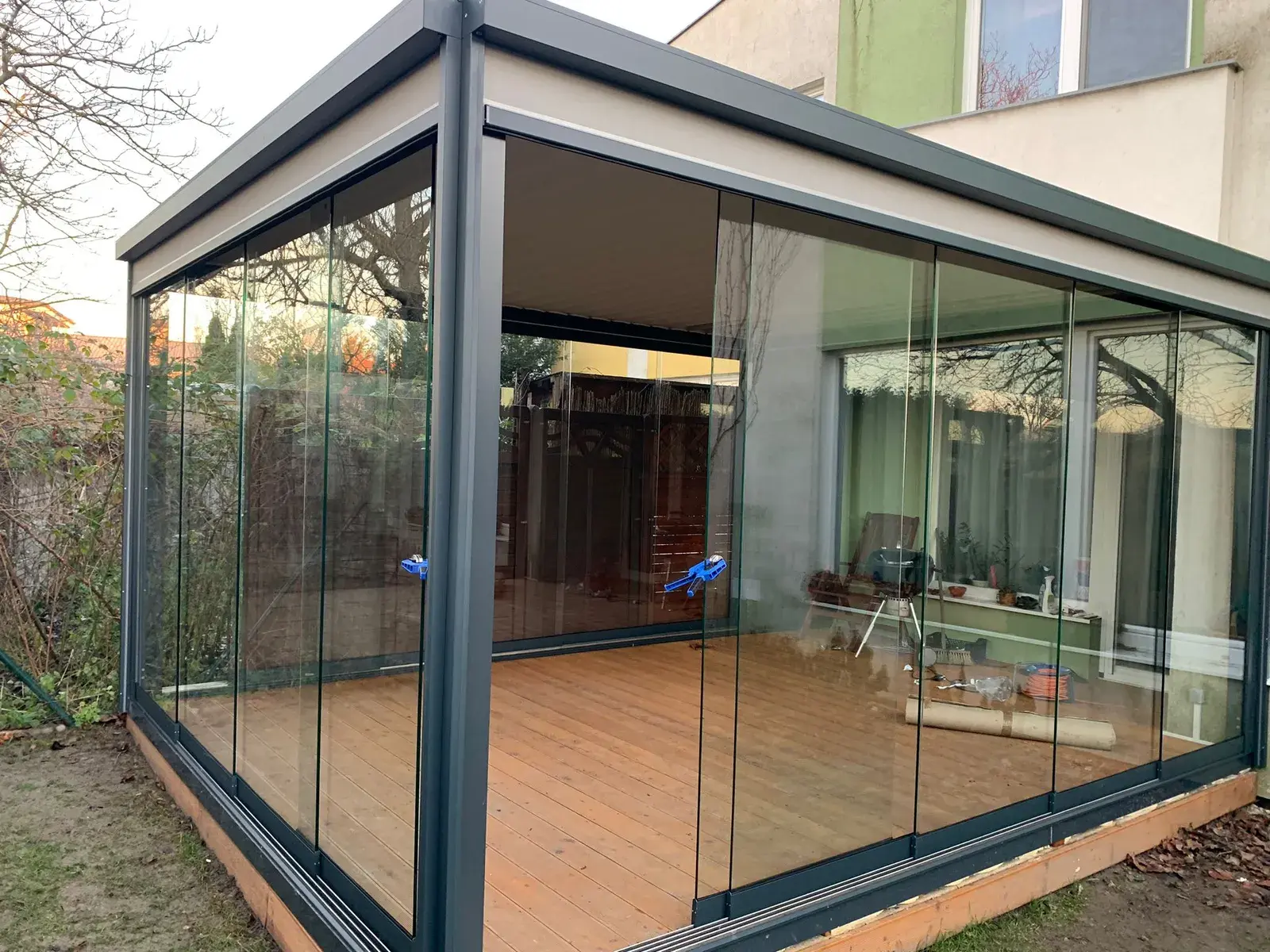 Pergola s posuvnými sklami a drevenou podlahou