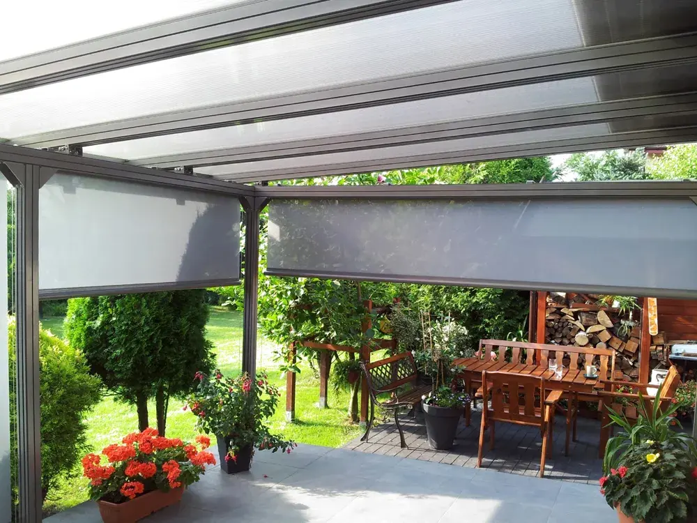 Pergola s priesvitnou strechou a screenmi nad sedením v záhrade